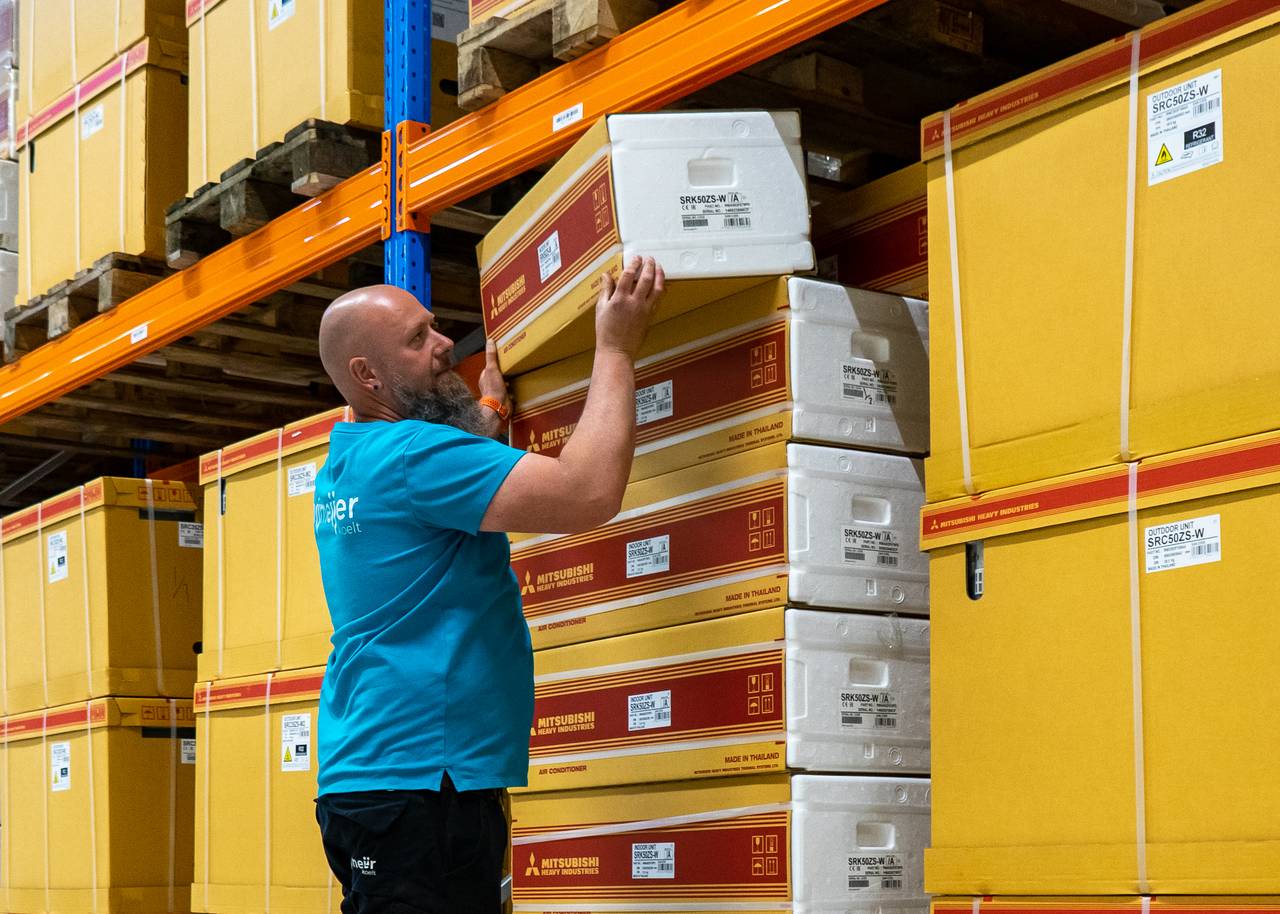 Medewerker van Nijmeijer Koelt pakt een doos van airconditioning uit het magazijn