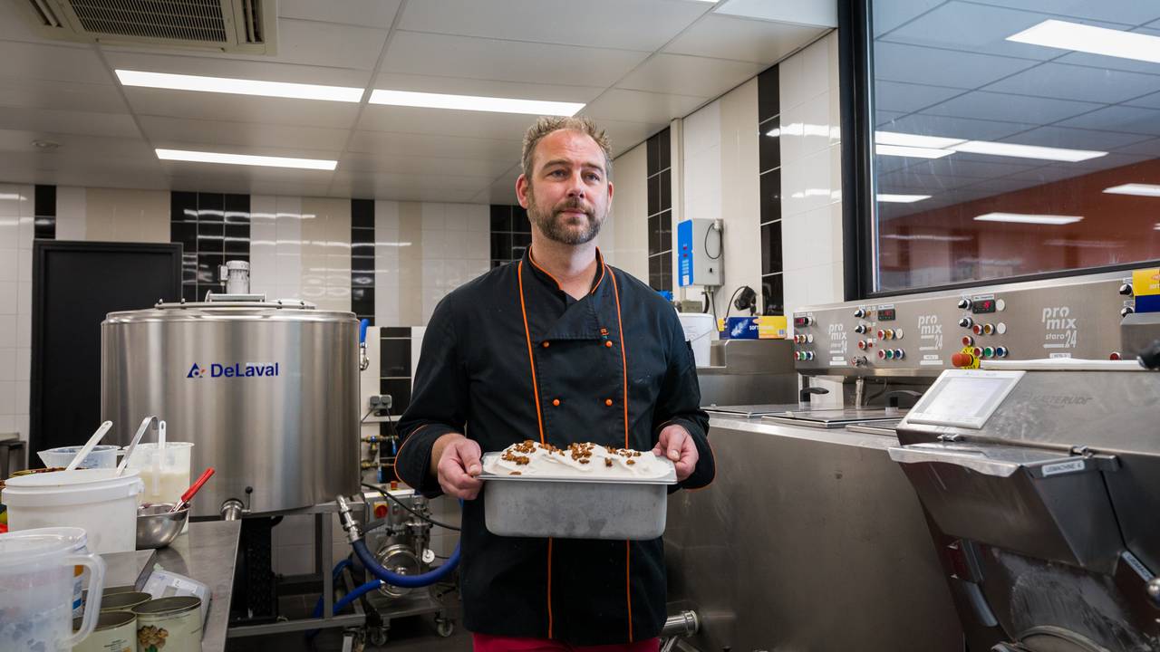 Toscana eigenaar loopt met een bak vol ijs tussen machines door