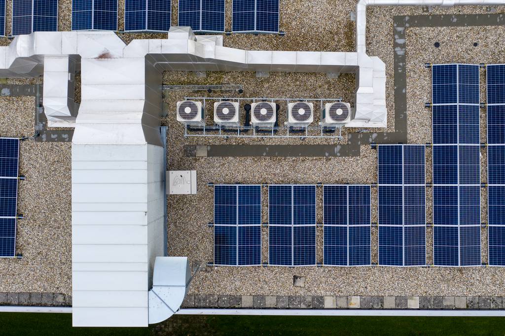 Een VRF systeem op het dak vanaf boven weergegeven naast een antal Zonnepanelen